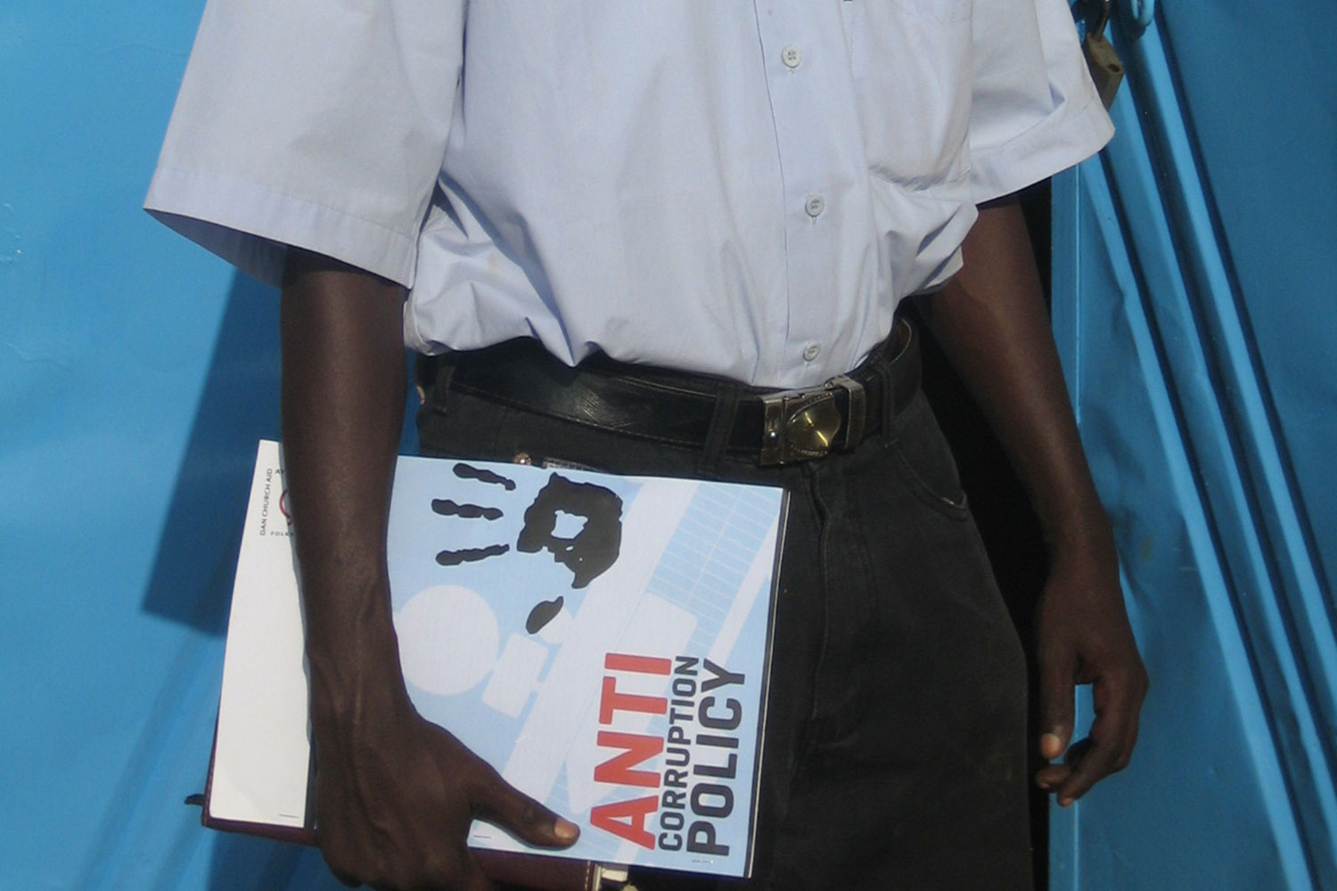 Mand st&aring;r med mappe, hvor der st&aring;r anti-korruptionspolitik p&aring;